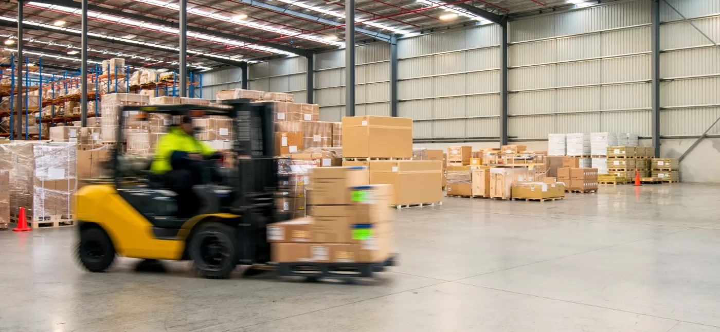 Forklift in warehouse carrying boxes
